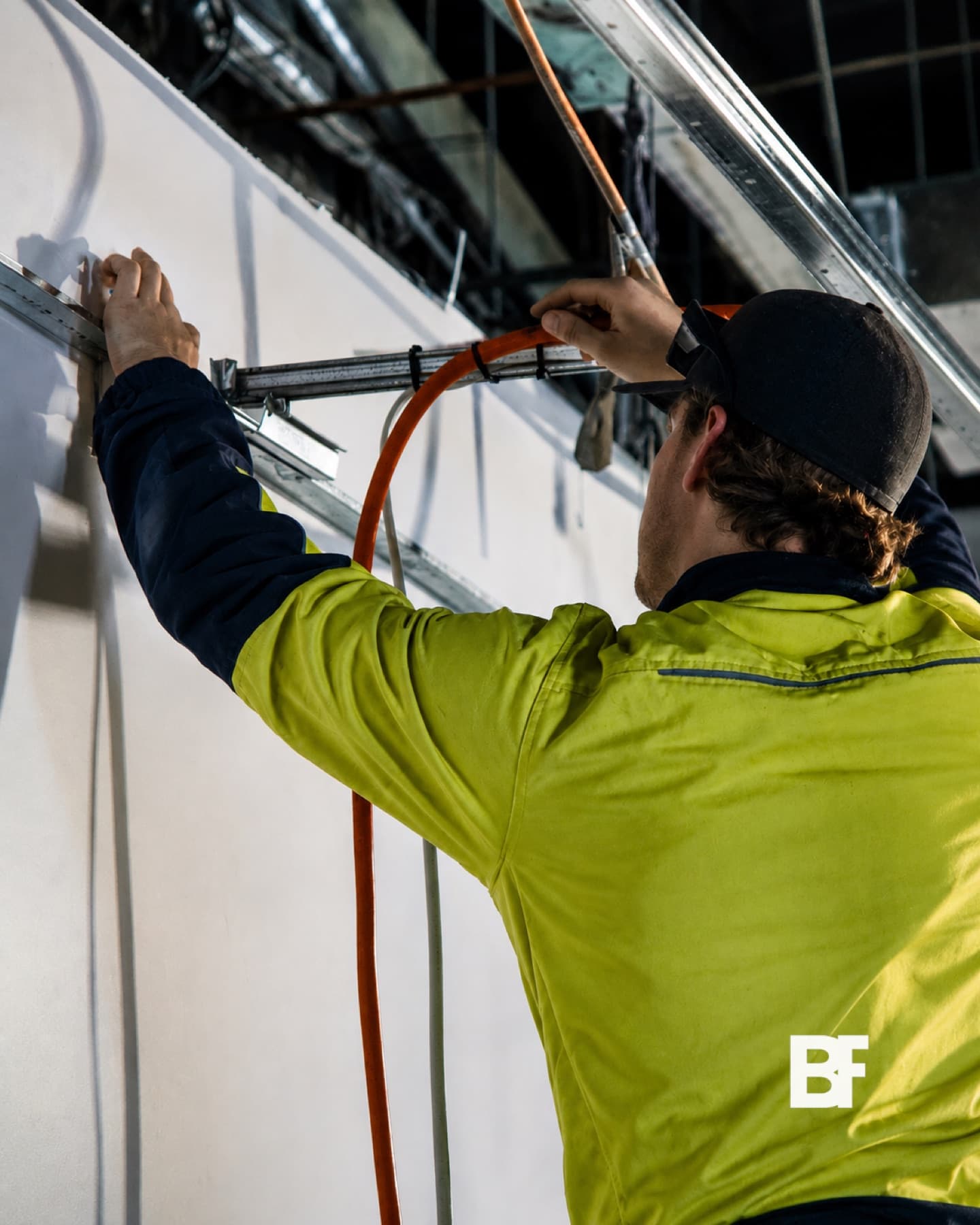 Construction worker installing facade glazing on a Perth project