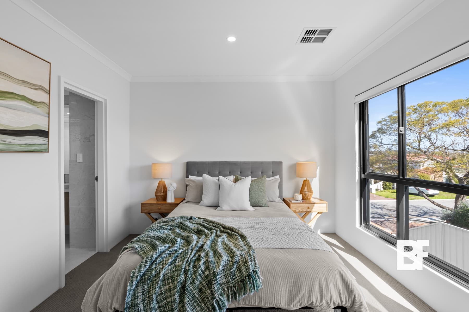 Bright styled bedroom with large corner windows photographed by BASEFORM